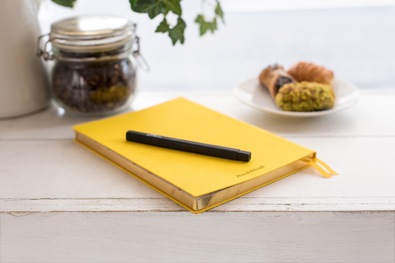 Ein gelbes Notizbuch liegt auf einer hellen Ablage, Darstellung der Coaching Einzelsitzungen